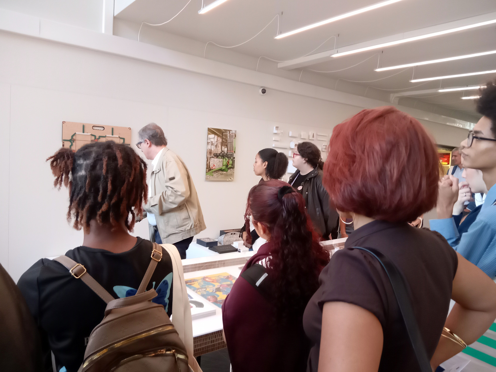 Participantes observam os produtos e as fotografias apresentados na exposição