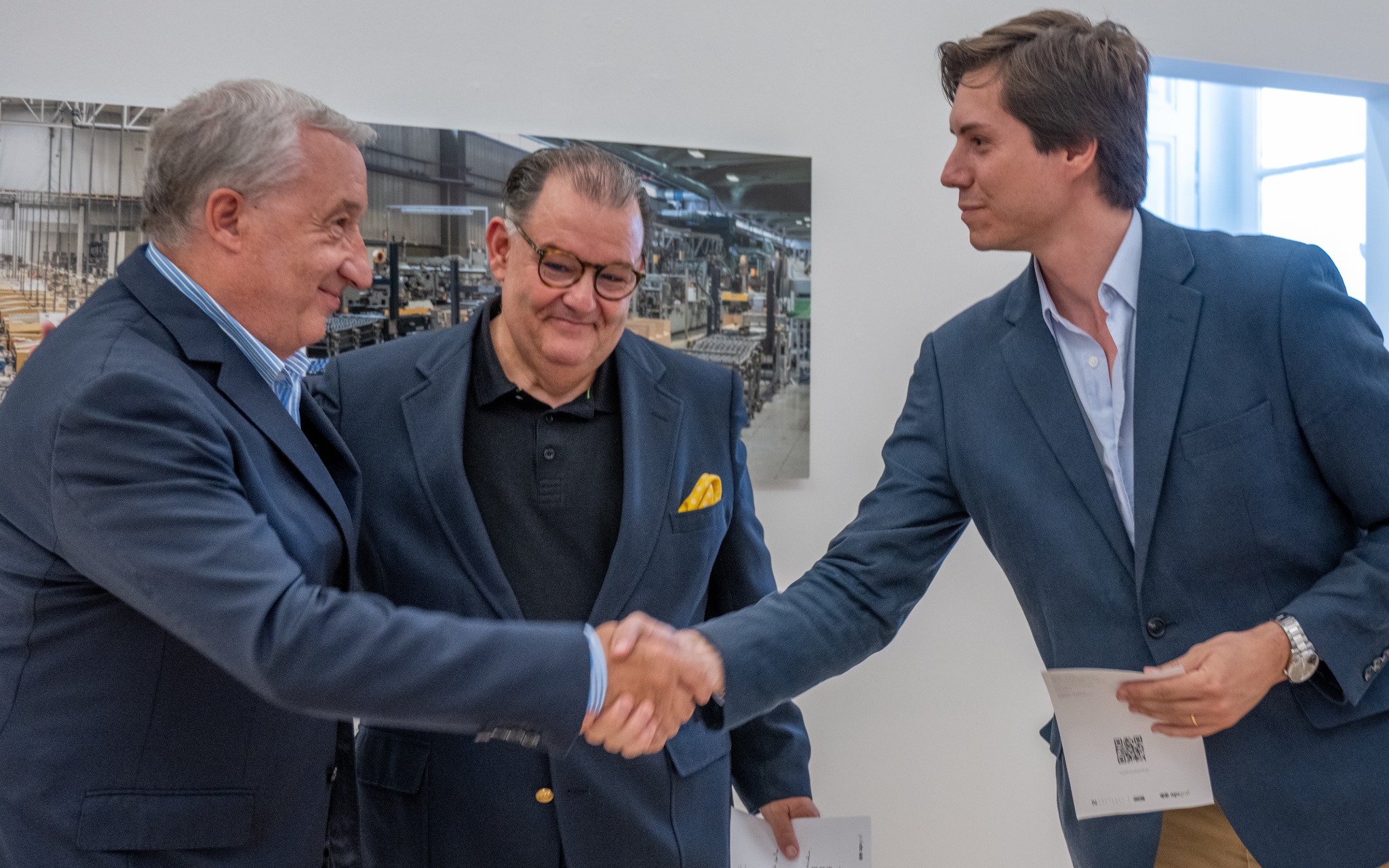 Cumprimento entre participantes durante a inauguração da exposição